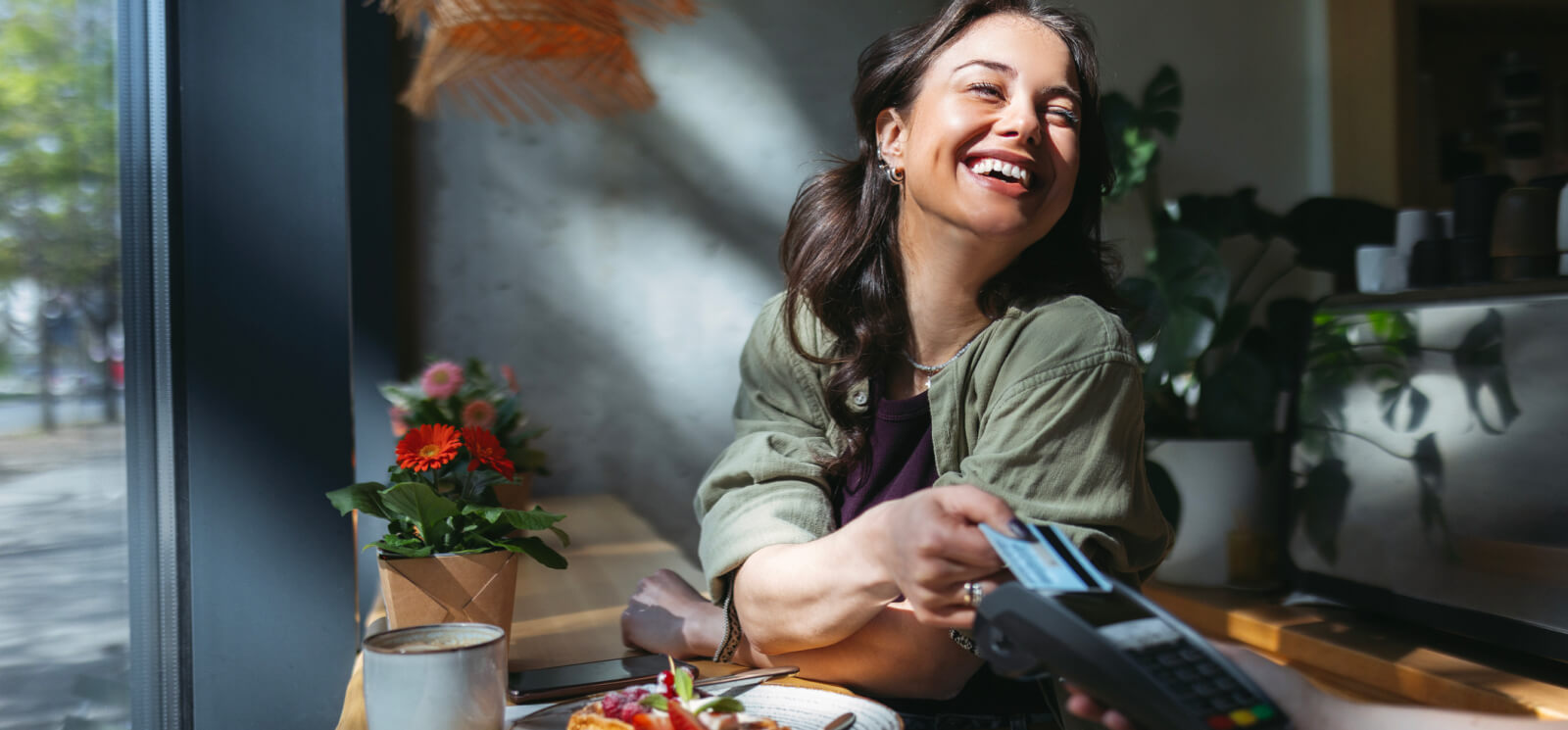 Young woman holding a credit card up to a card reader