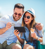 Couple on vacation holding debit card, phone, and ice cream. 