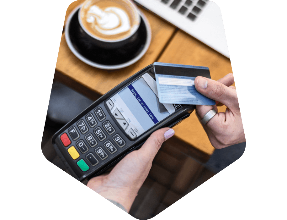 Close-up of hands holding a credit card up to a card reader